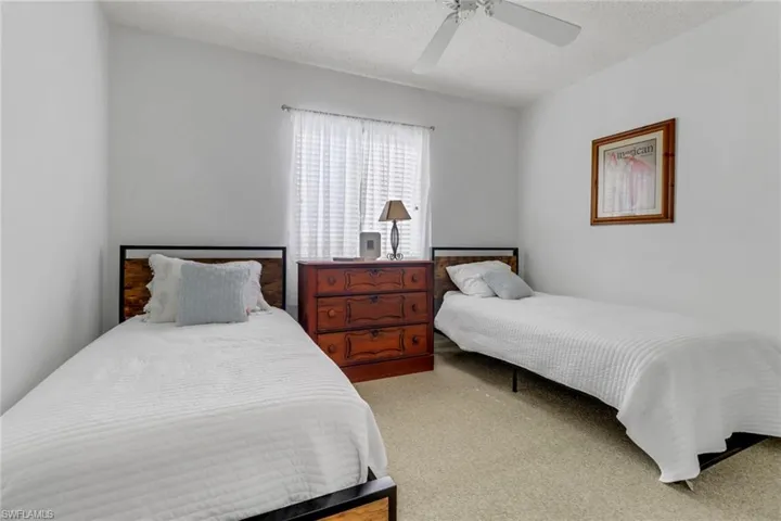 Carpeted bedroom featuring ceiling fan and a textured ceiling