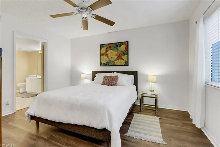 Bedroom featuring hardwood / wood-style floors, ceiling fan, a textured ceiling, and connected bathroom