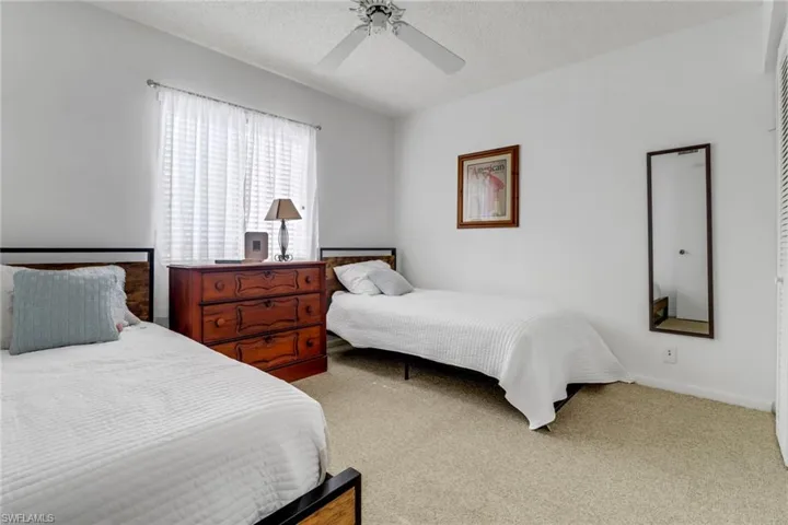 Bedroom featuring ceiling fan, carpet floors, and a textured ceiling