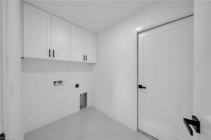 Washroom with hookup for an electric dryer, cabinet space, and washer hookup