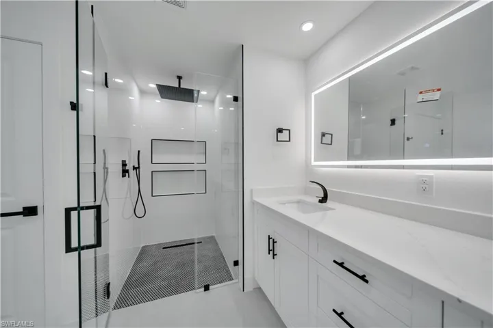 Full bath with a shower stall and vanity