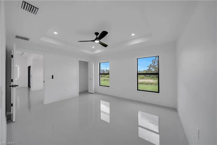 Unfurnished room with a tray ceiling, recessed lighting, tile patterned flooring, and ceiling fan
