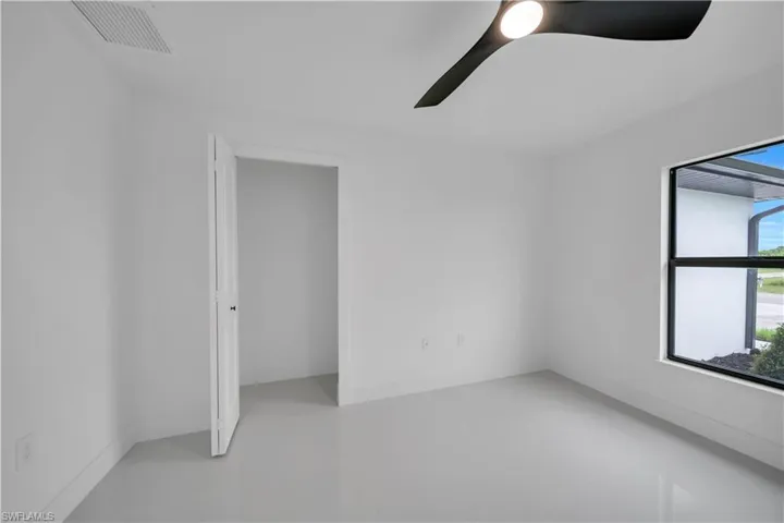 Tiled spare room with a ceiling fan