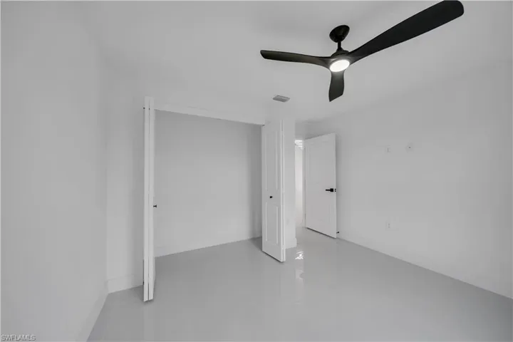 Unfurnished bedroom featuring tile patterned flooring, a closet, and a ceiling fan