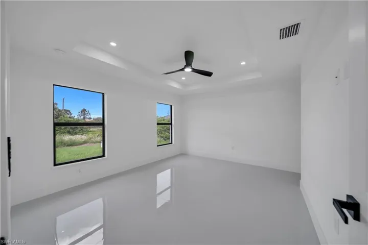 Spare room featuring a raised ceiling, recessed lighting, and a ceiling fan