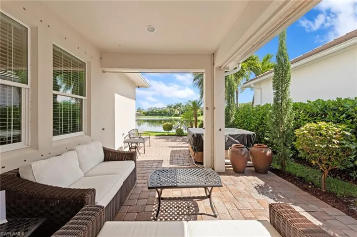 View of paver lanai featuring an outdoor hangout area and a water view. NEW HOT TUB (2020), NEW EXTENDED PAVER LANAI (2021), NEW LANDSCAPING (2021), NEW EXTERIOR SECURITY CAMERAS (2025)