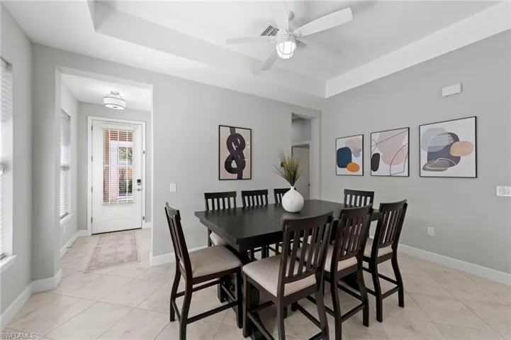 Dining area with TILE FLOOR and TRAY CEILING. NEW CEILING FAN (2017), NEW WINDOW BLINDS (2017), NEW ECOBEE THERMOSTAT (2024)