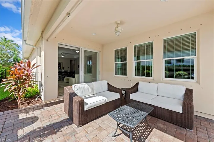 Covered paver patio with IMPACT GLASS SLIDING DOOR. NEW CEILING FAN (2017), NEW EXTENDED PAVER LANAI (2021), NEW LANDSCAPING (2021), NEW EXTERIOR SECURITY CAMERAS (2025)
