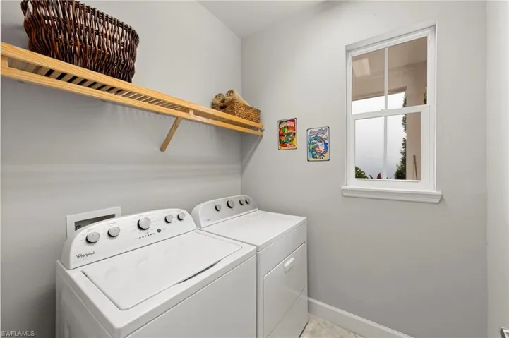 Laundry with washer, clothes dryer, TILE FLOOR, IMPACT GLASS WINDOW, and storage shelving/drying rod.