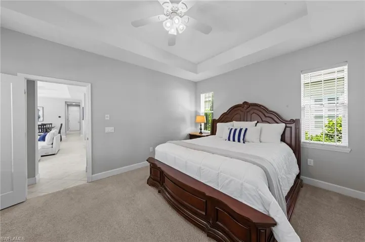Primary suite with TRAY CEILING, carpet and WALK-IN CLOSET. NEW CEILING FAN (2017), NEW WINDOW BLINDS (2017)