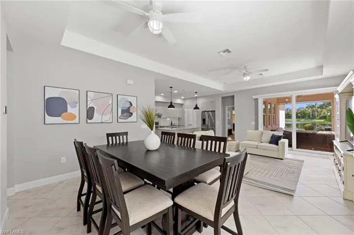 Dining area with TILE FLOOR and TRAY CEILING. NEW CEILING FANS (2017), NEW KITCHEN PENDANTS (2023)