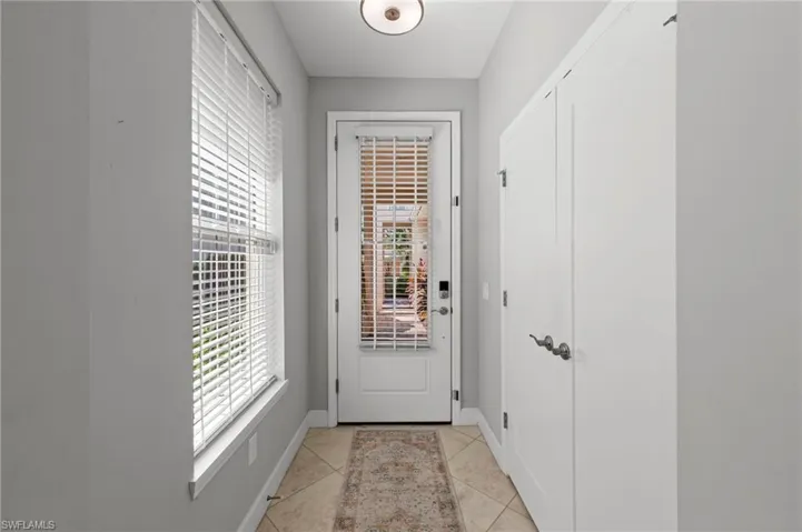 Large inviting entry with IMPACT GLASS DOOR, KEYPAD ENTRY LOCK, storage closet and tile floor. NEW WINDOW BLINDS (2017), NEW RING VIDEO DOOR BELL (2024)