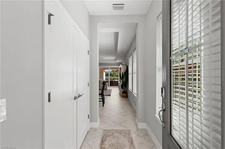 Large inviting entry with IMPACT GLASS DOOR, KEYPAD ENTRY LOCK, storage closet and tile floor. Once you walk into the home you can see the expansive water views. NEW WINDOW BLINDS (2017)