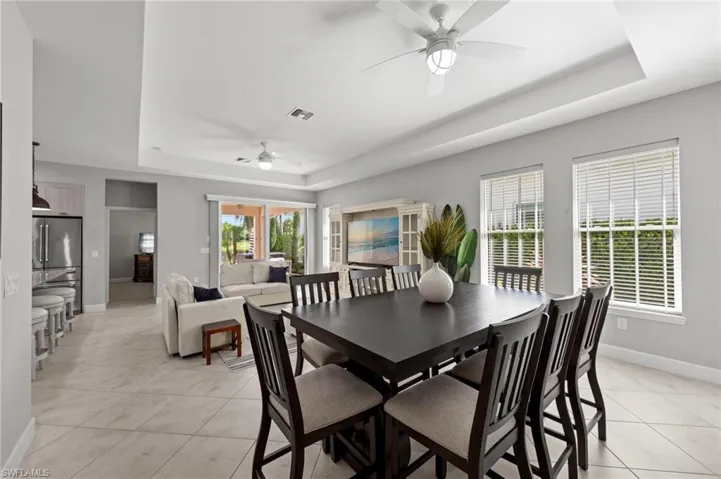 Dining area with TILE FLOOR and TRAY CEILING. NEW CEILING FANS (2017), NEW WINDOW BLINDS (2017)
