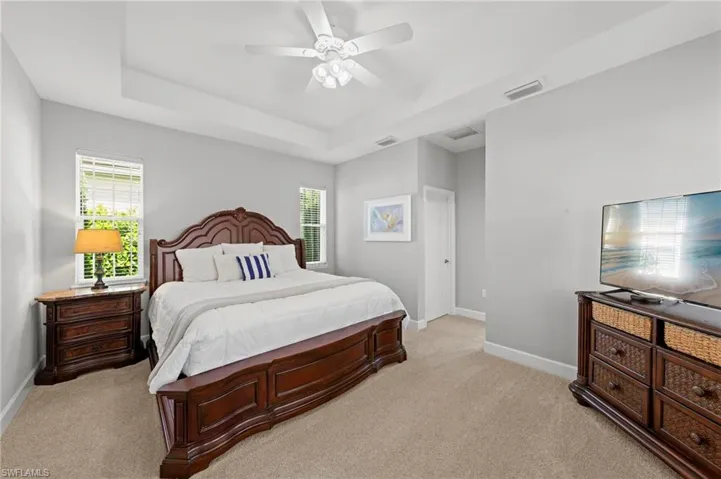 Primary suite with TRAY CEILING, carpet and WALK-IN CLOSET. NEW CEILING FAN (2017), NEW WINDOW BLINDS (2017)