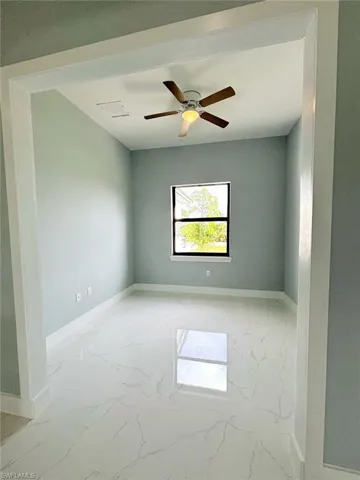 Tiled empty room featuring ceiling fan