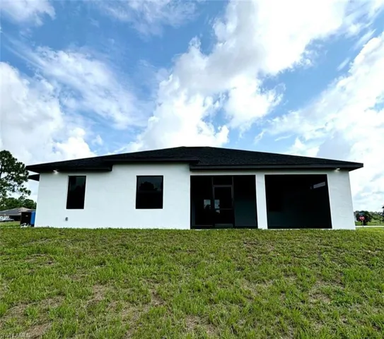 Back of house with a lawn