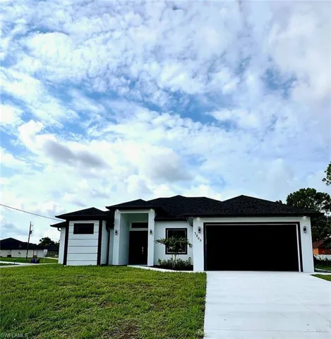 View of front of house with a front lawn and a garage