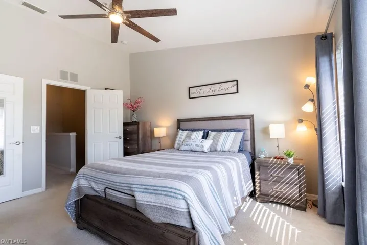 Carpeted bedroom with ceiling fan and baseboards