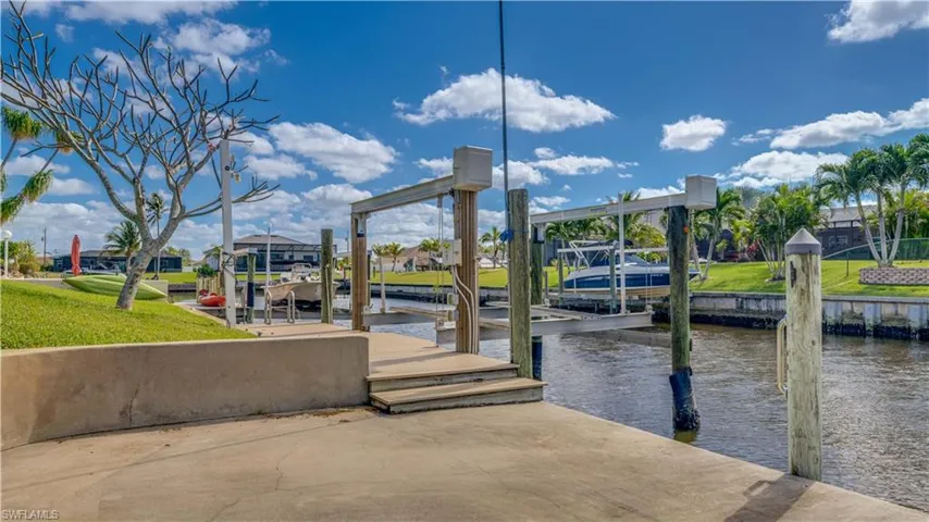 Dock area with a yard and a water view