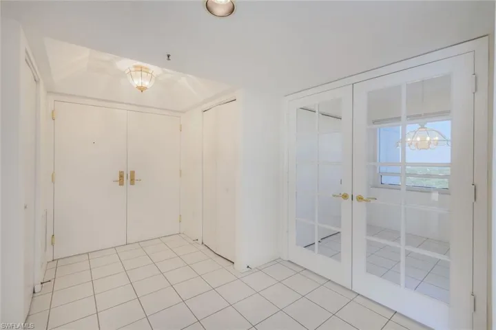 Foyer with light tile patterned floors and french doors