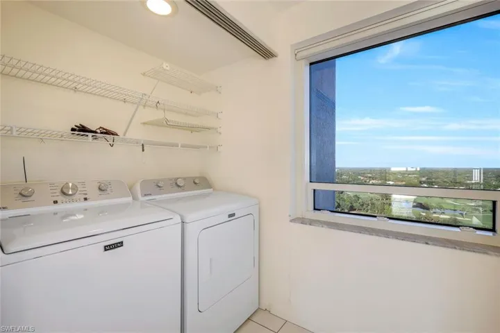 Laundry room featuring a healthy amount of sunlight, washing machine and dryer, and light tile patterned flooring