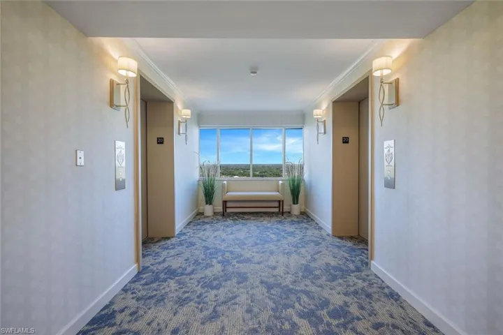 Corridor featuring elevator, carpet floors, and ornamental molding