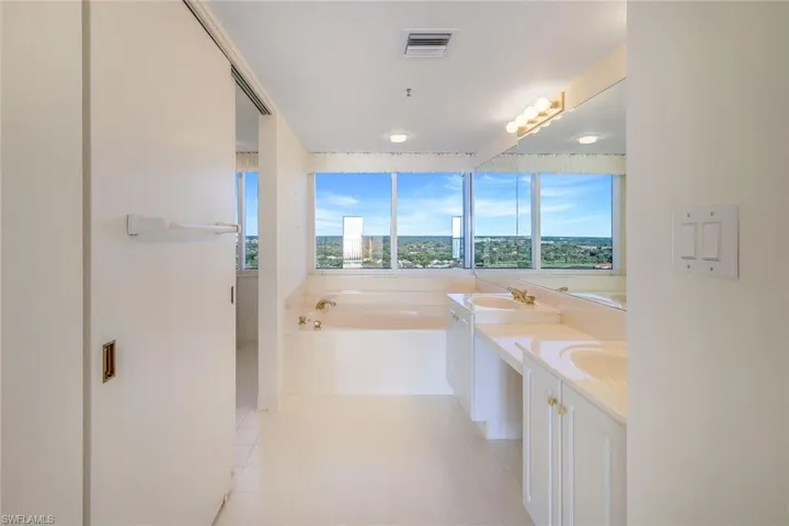 Bathroom featuring vanity, a tub to relax in, and tile patterned floors