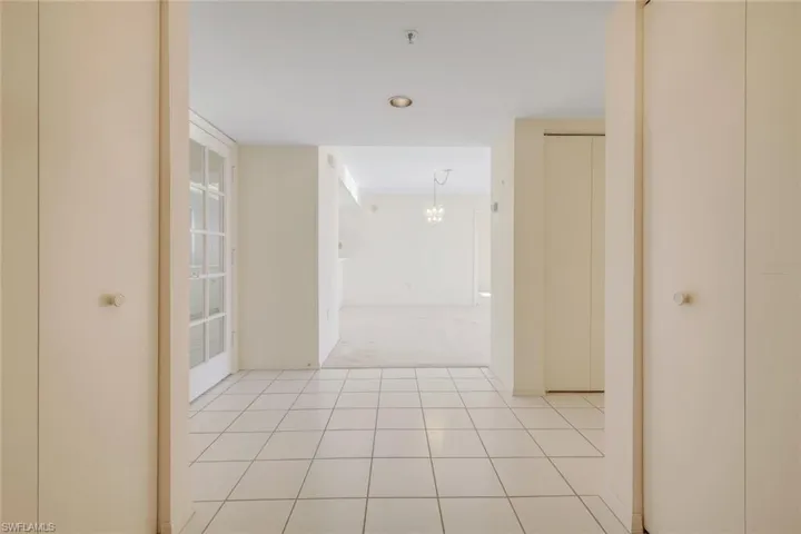 Corridor featuring a chandelier and light tile patterned floors