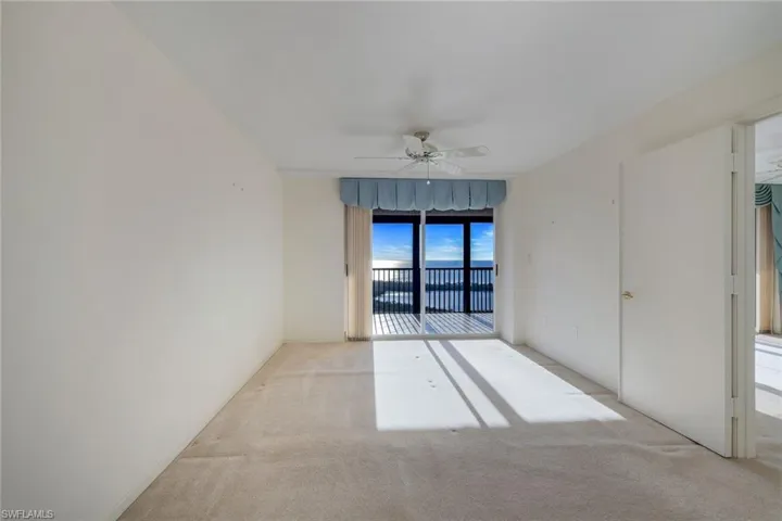 Empty room with ceiling fan and light carpet