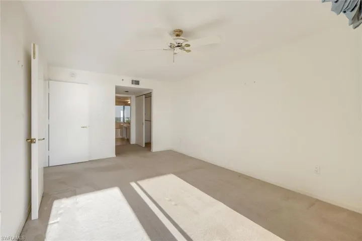 Carpeted empty room with ceiling fan