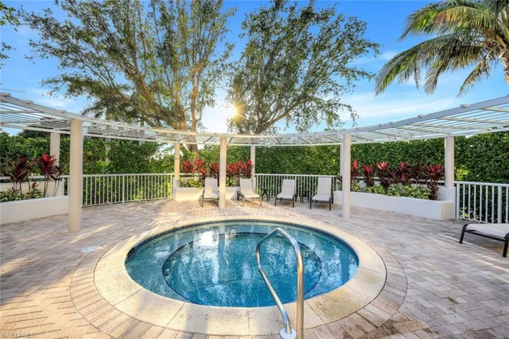 View of pool featuring a patio area, a pergola, and an in ground hot tub
