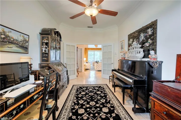 Office with ornamental molding and ceiling fan