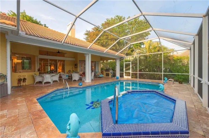 View of swimming pool with an in ground hot tub, ceiling fan, a patio area, and glass enclosure
