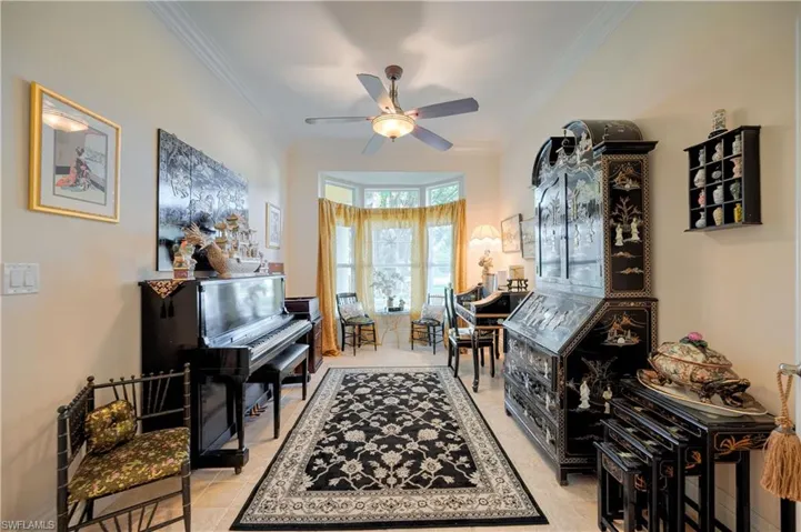 Misc room featuring ornamental molding, light tile patterned flooring, and ceiling fan