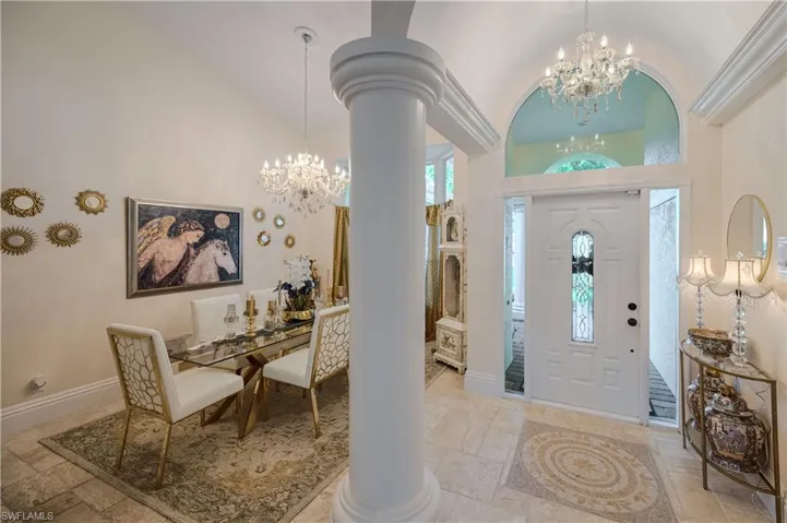 Entryway featuring an inviting chandelier, high vaulted ceiling, and ornate columns