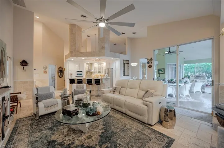 Living room featuring a high ceiling and ceiling fan