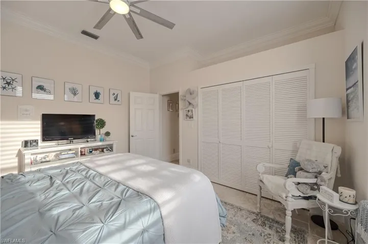 Bedroom with crown molding, ceiling fan, and a closet