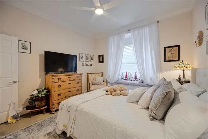 Bedroom with crown molding, ceiling fan, and hardwood / wood-style flooring