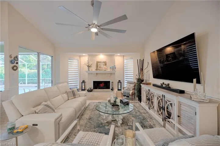 Living room featuring ceiling fan and lofted ceiling