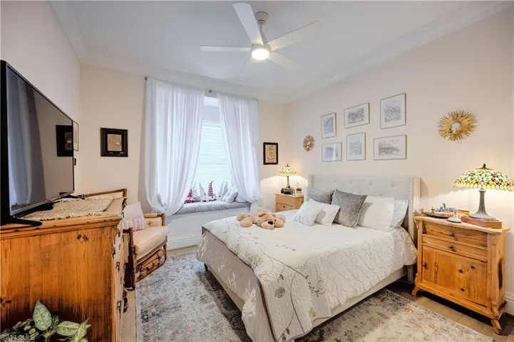 Bedroom with crown molding, ceiling fan, and light hardwood / wood-style flooring