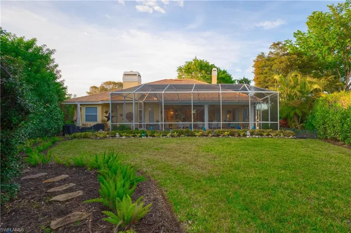 Rear view of property featuring a yard and a lanai