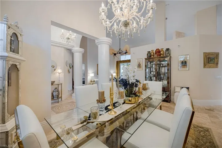 Dining space with decorative columns, a high ceiling, and a chandelier