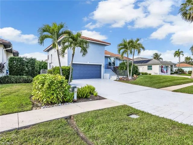 Mediterranean / spanish-style home with stucco siding, a front lawn, concrete driveway, a tiled roof, and a garage
