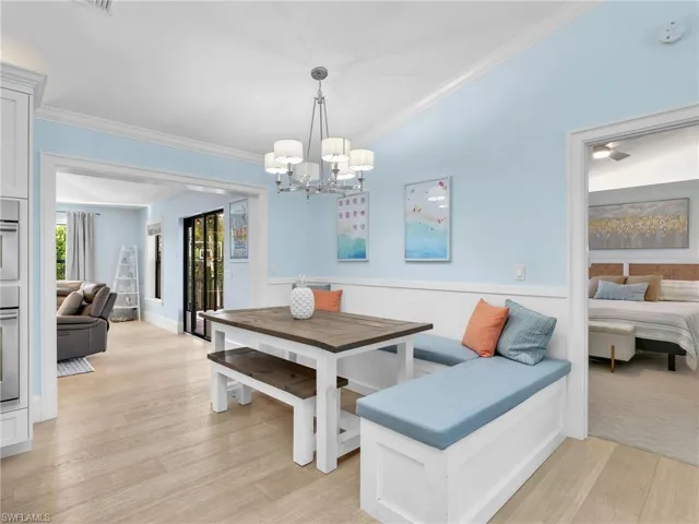 Dining area featuring ornamental molding, wainscoting, light wood-type flooring, and breakfast area