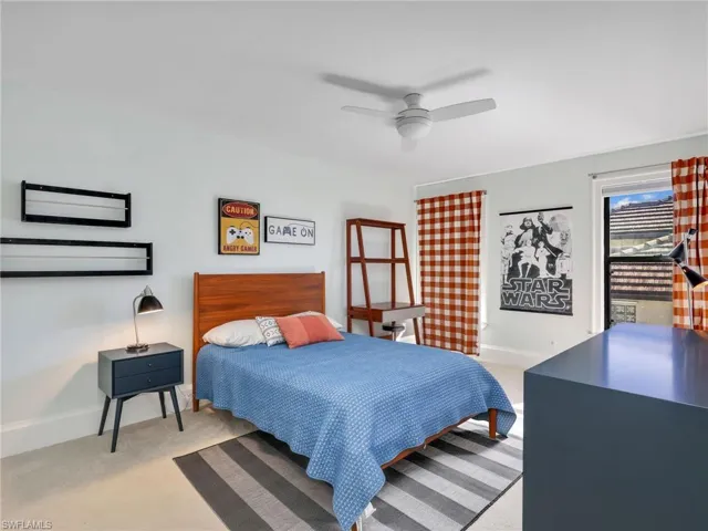 Bedroom with a ceiling fan and light carpet