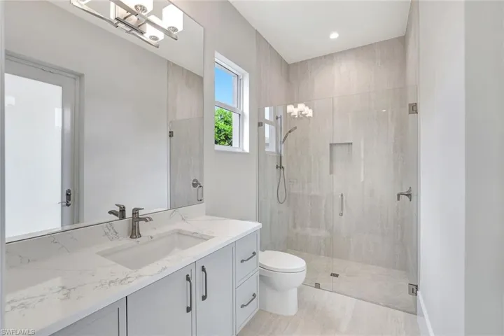 Full bathroom featuring vanity, a stall shower, and a chandelier