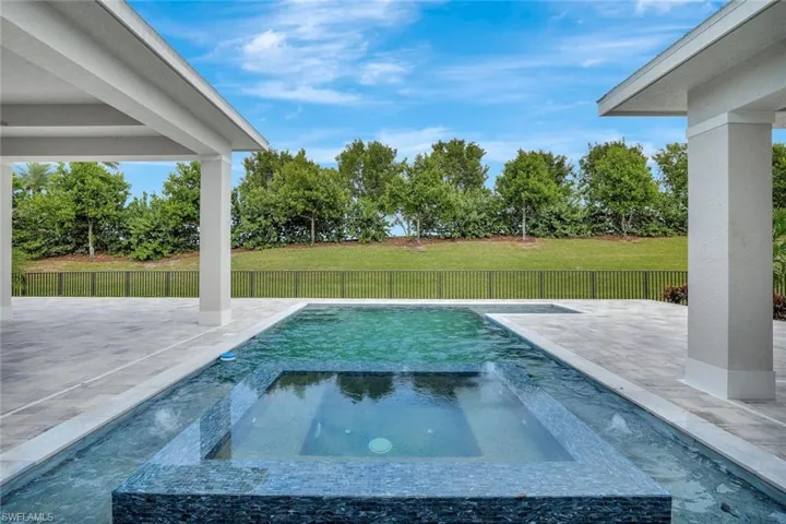 View of pool featuring a patio area, a fenced backyard, and a pool with connected hot tub