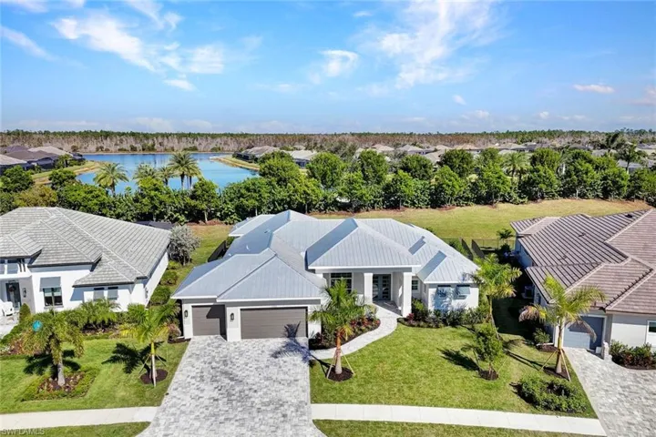 Aerial perspective of suburban area with a large body of water and a tree filled landscape