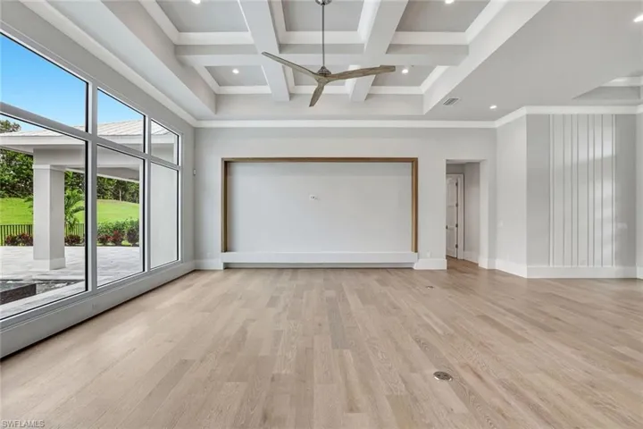 Unfurnished living room featuring coffered ceiling, beamed ceiling, light wood-type flooring, a ceiling fan, and recessed lighting